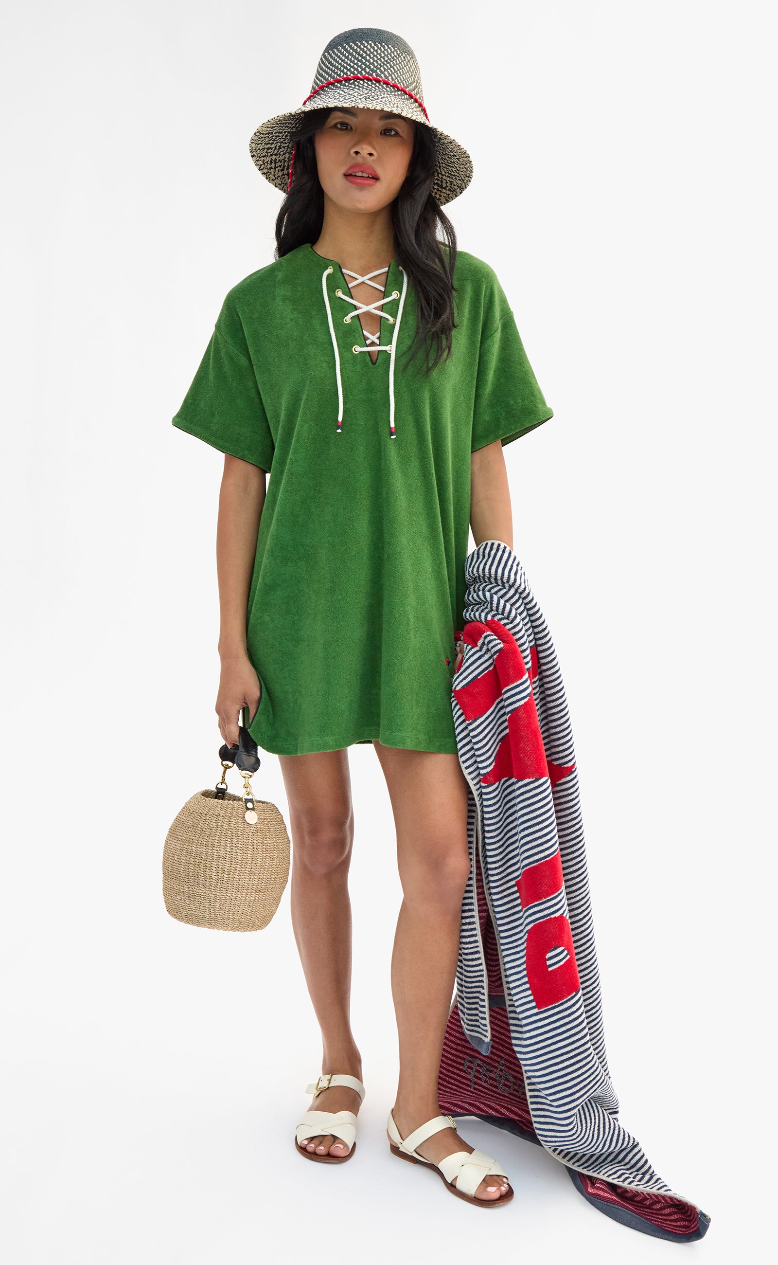 Model wearing La Plage Dress and Romy Hat while carrying Le Towel and Cream Pot de Miel.