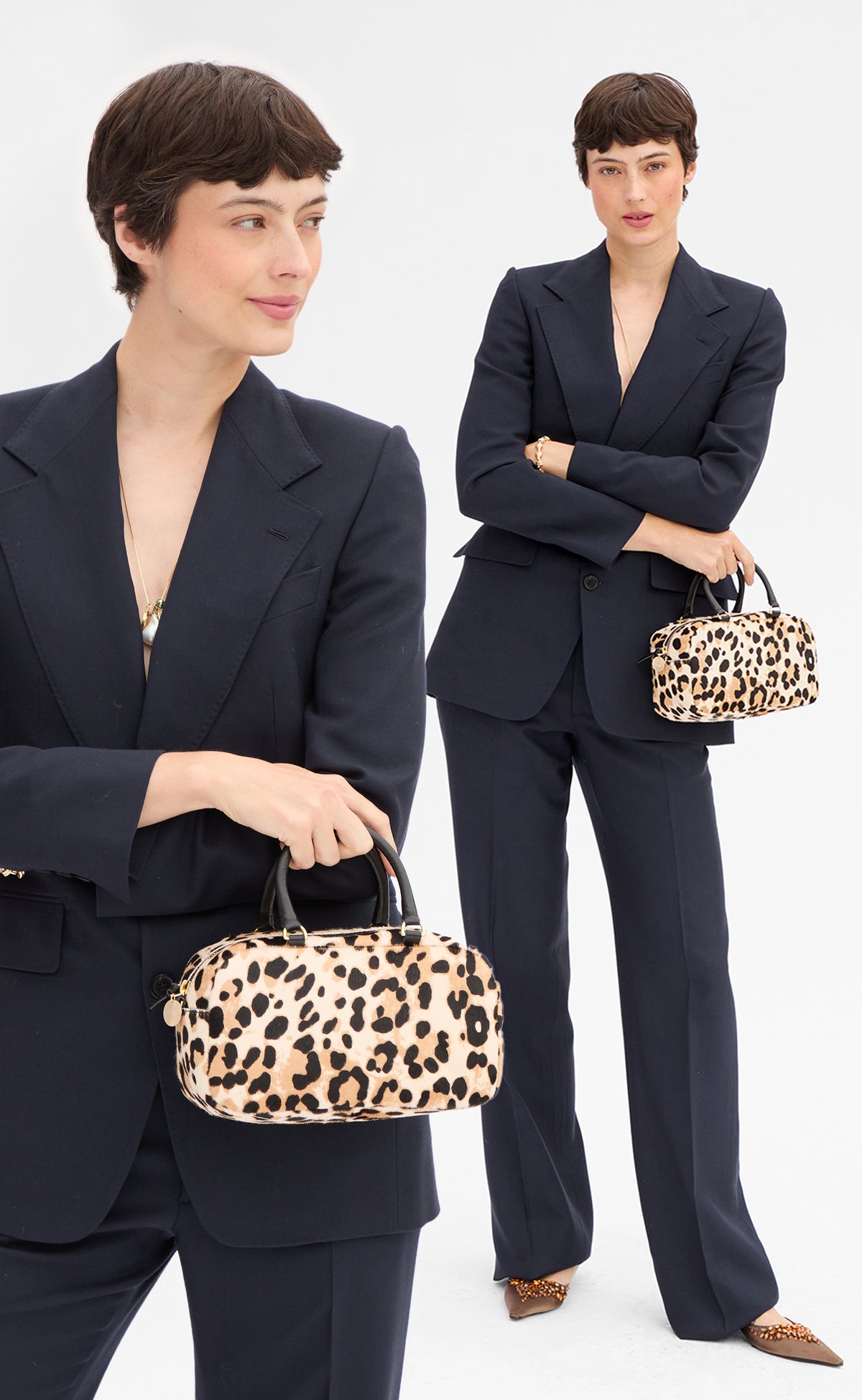 Model carrying the Snow Leopard Petite Claudine as a top handle bag. 
