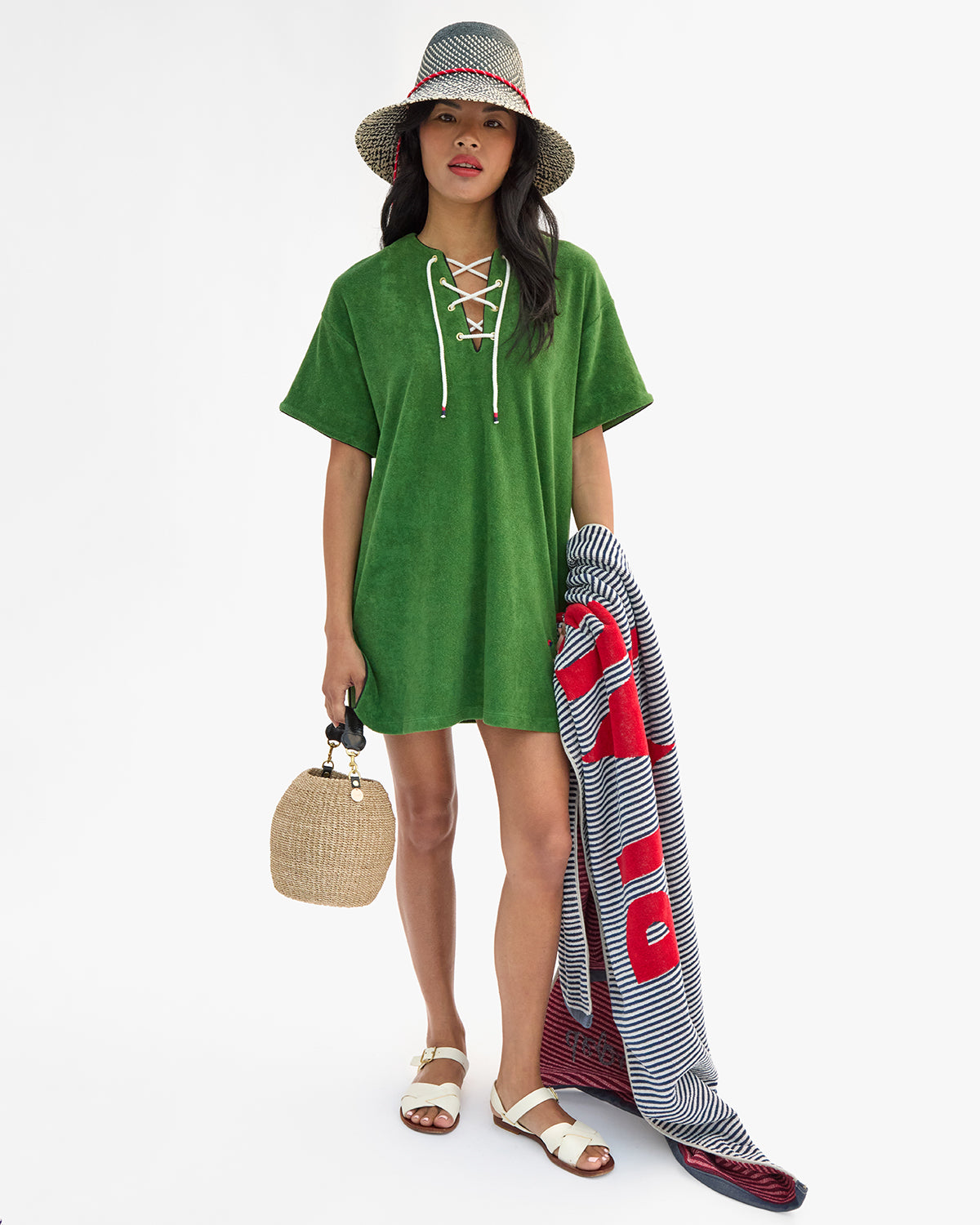 Model wearing La Plage Dress and Romy Hat while carrying Le Towel and Cream Pot de Miel.