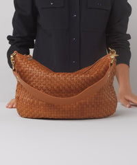 Model shows what fits in the Natural Woven Checker Moyen Messenger