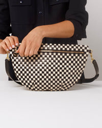 Model shows what fits in the Black and Cream Woven Checker Grande Fanny