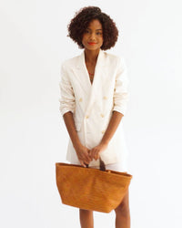 Vitoria spins around while holding the Bateau Tote by the top handle then takes out the longer straps and puts the bag on her shoulder