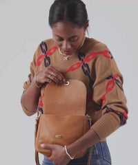 Mecca holding the Tan Pebble Turnlock Louis and putting it over her shoulder and also crossbody.