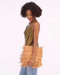 Vitoria walks holding the Fringe Clutch