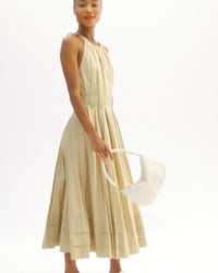 Model carrying the Cream Woven Checker Petit Moyen as a top handle bag via the shoulder strap and then carrying the bag as a shoulder bag. 