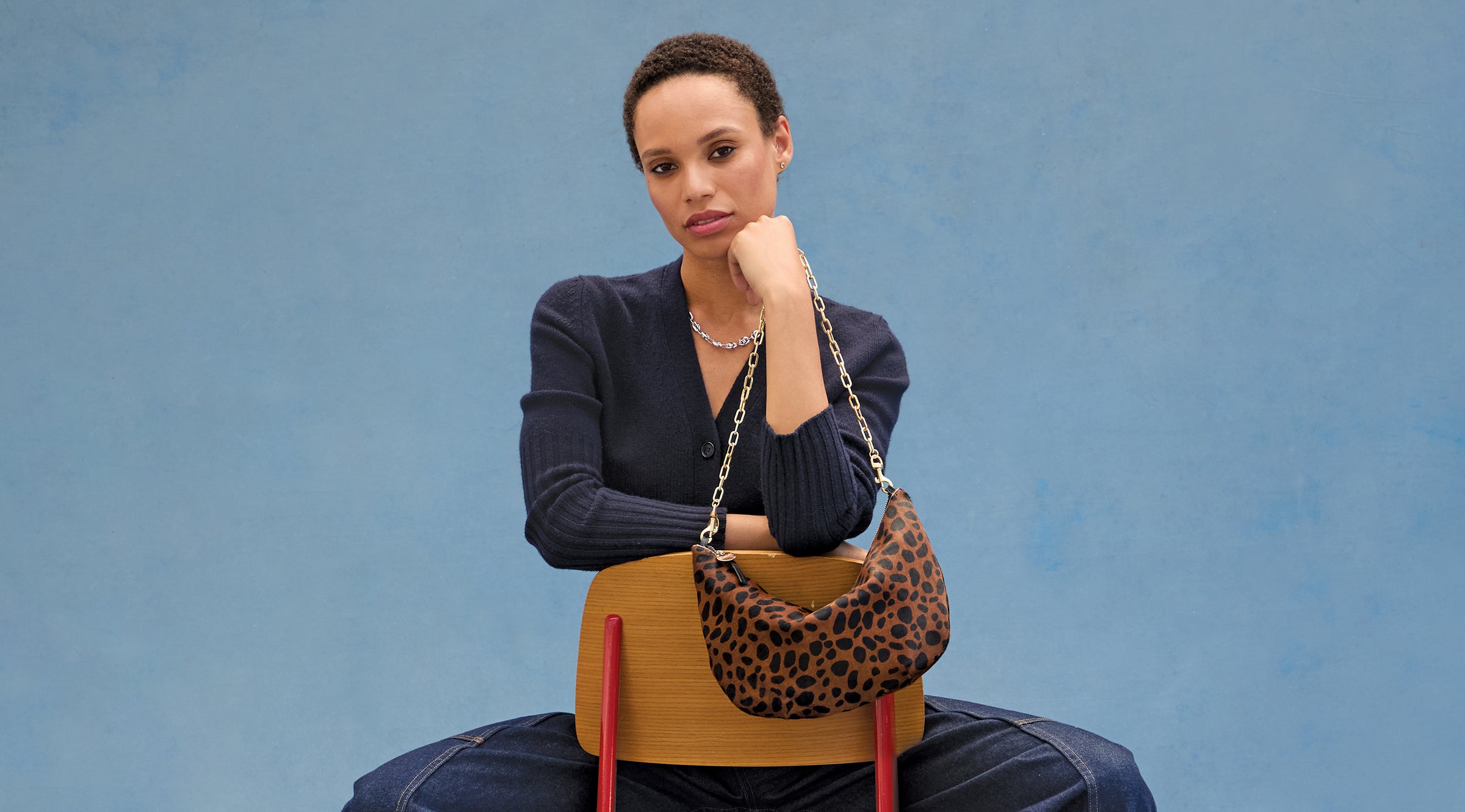 Model carrying the Leopard Lune with a Gold Oval Chain Shoulder Strap.