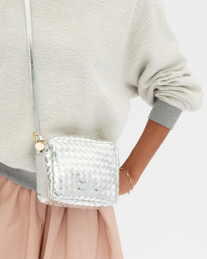 Model carrying the Silver Diagonal Woven Midi Sac as a crossbody bag. 