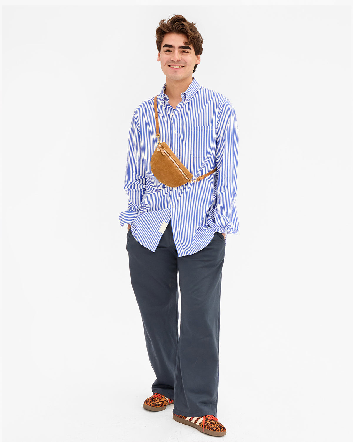 Male model carrying the Caramel Suede Petite Fanny Pack over and across his chest. 