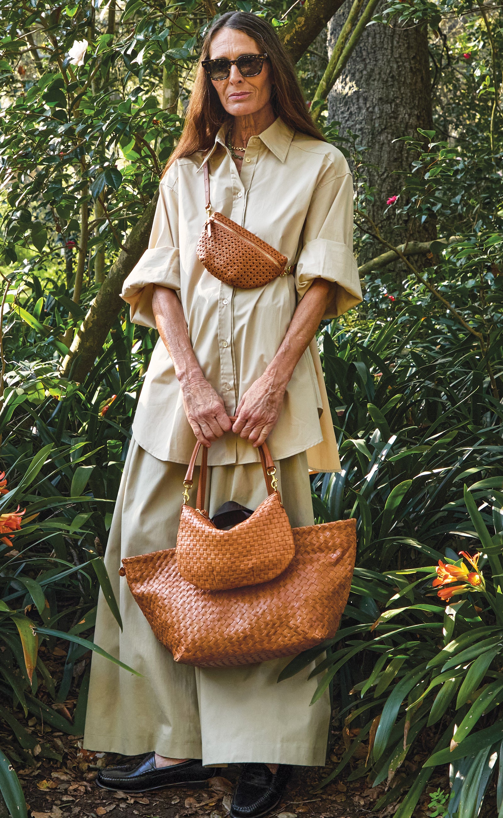 Woman carrying the Tan Rattan Petite Fanny across her chest while carrying the Natural Woven Petit Moyen and Natural Woven Diagonal Bateau Tote.