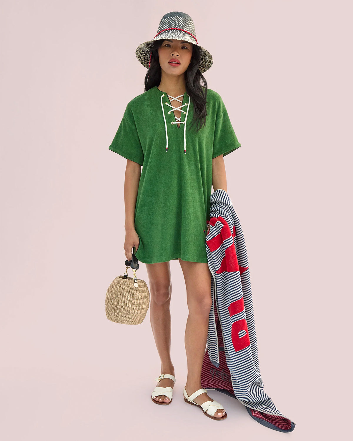 Model wearing the Basil La Plage Dress while carrying the Pot de Miel and holding Le Towel.