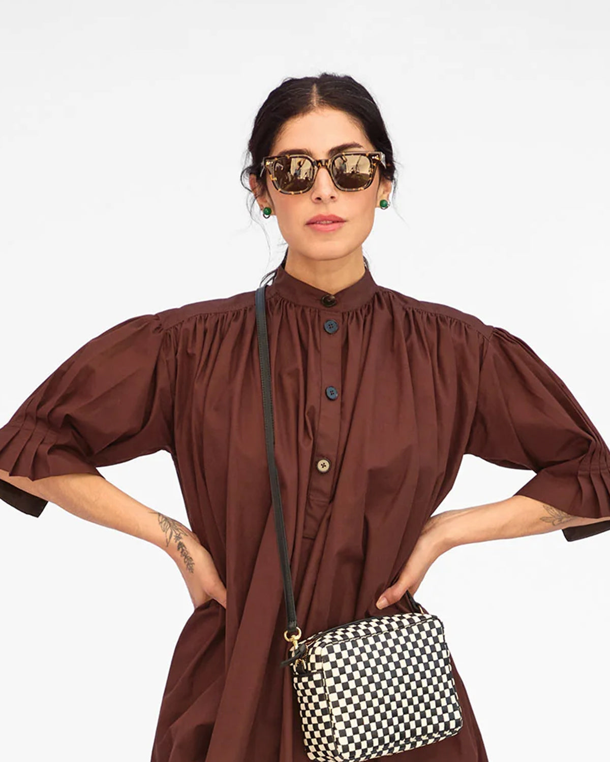 Model carrying the Black and Cream Checker Midi Sac as a crossbody bag. 