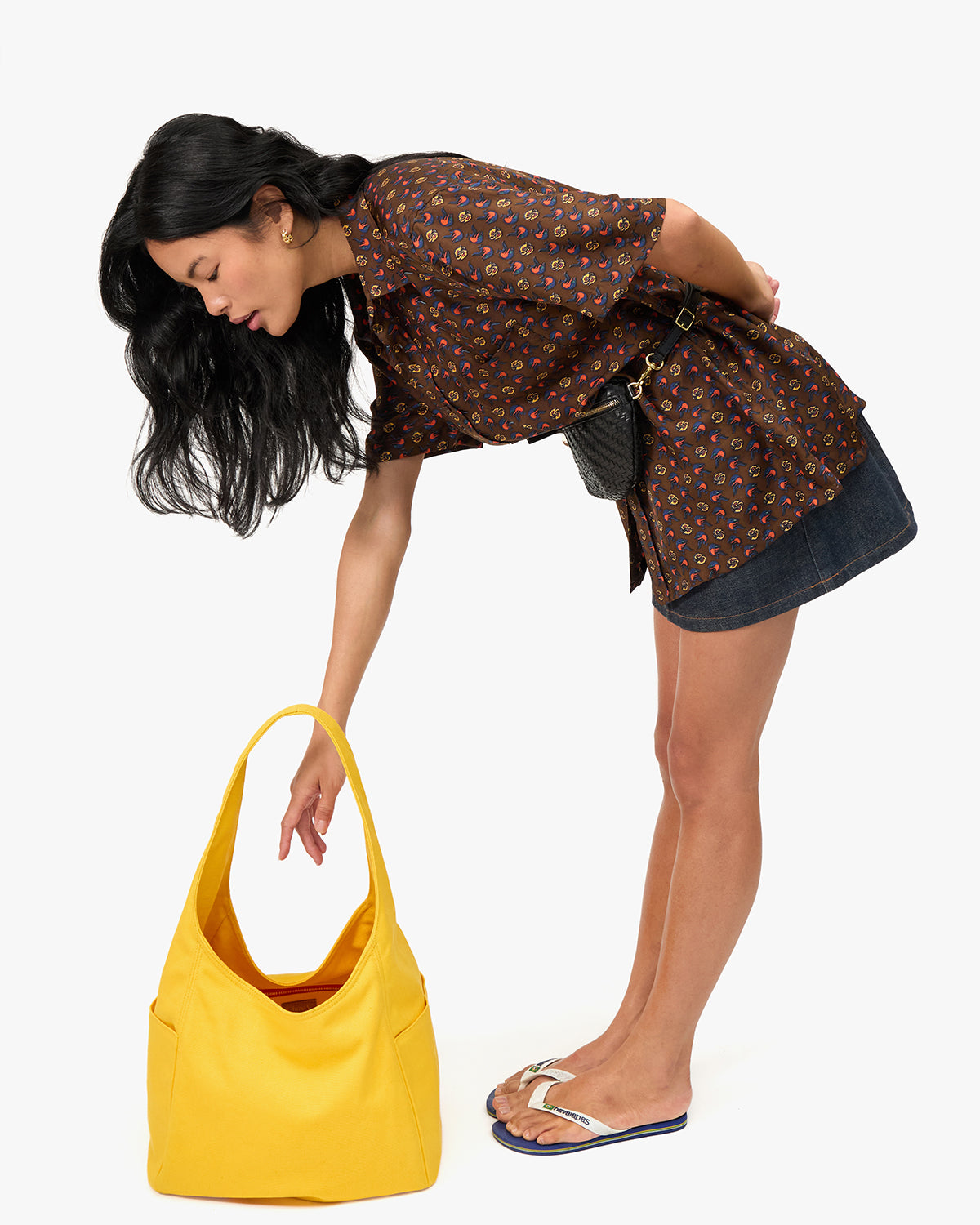 Model bending over to grab something inside of the Snapdragon Grand Bando that's sitting on the floor.