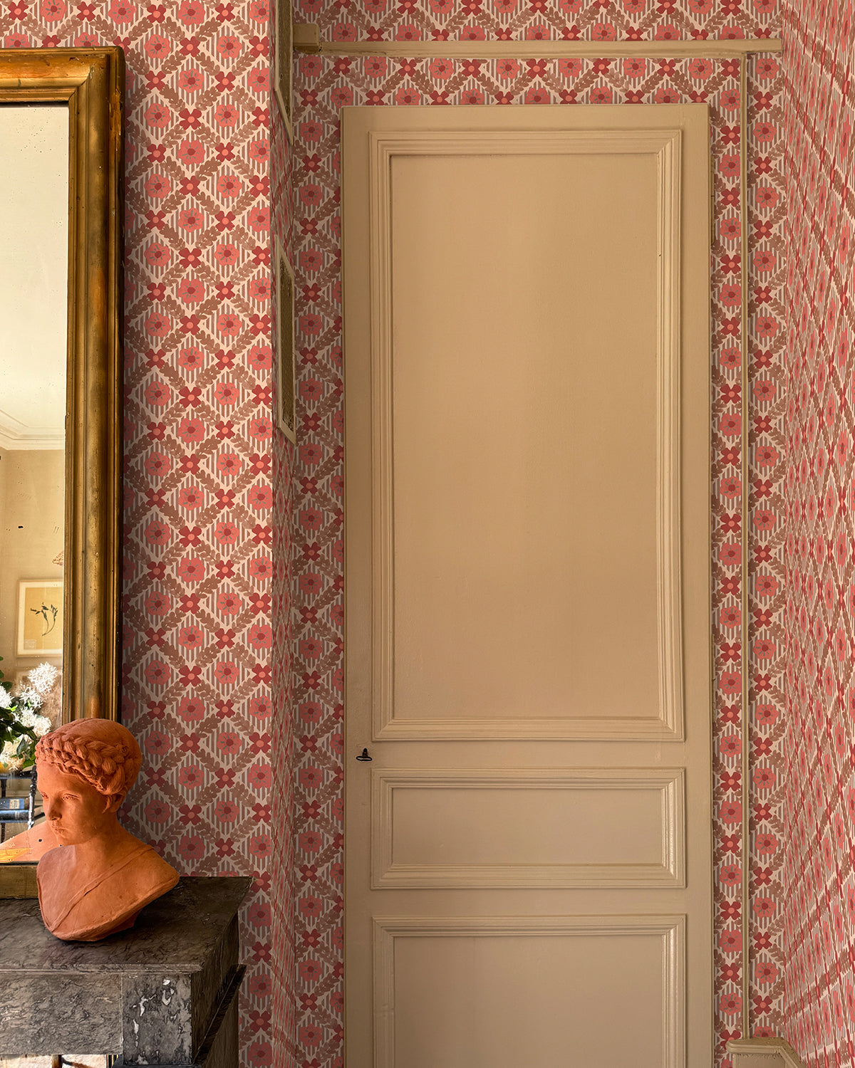 Room with pale pink door and 'Lattice Jardin' wallpaper.