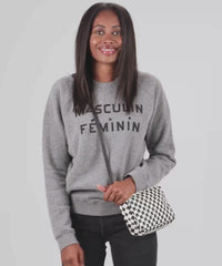 Mecca wearing the Black and White Checkers Midi Sac crossbody and taking out her lip balm out of the bag  to apply on her lips and put back in the bag. 