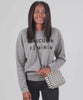 Mecca wearing the Black and White Checkers Midi Sac crossbody and taking out her lip balm out of the bag  to apply on her lips and put back in the bag. 