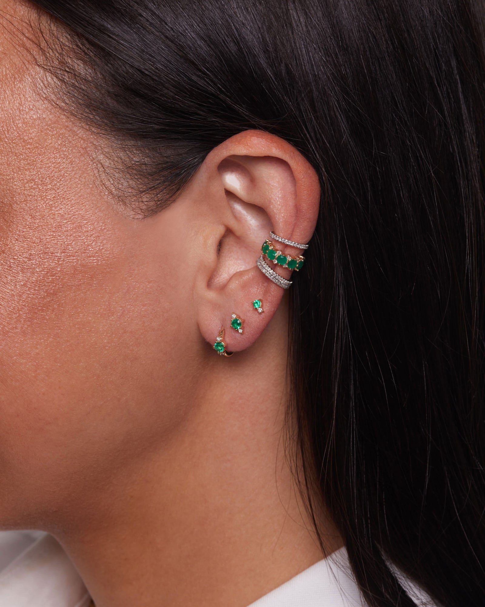 model wearing the Emerald & Diamond Trio Huggie Hoops in her first hole