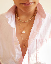 Andrea wearing the Baroque Pearl Charm on the Vermeil Rolo Chain. she's also wearing two other necklaces