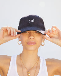 Aurelia wearing the Navy Corduroy Baseball Hat and touching the brim with her hands