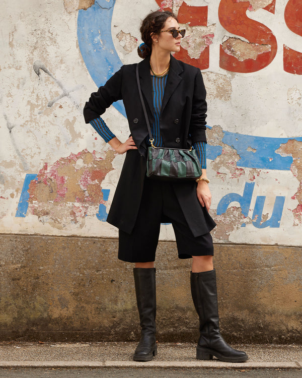celia wearing the Black & Deep Sea Belle crossbody with a black coat and boots