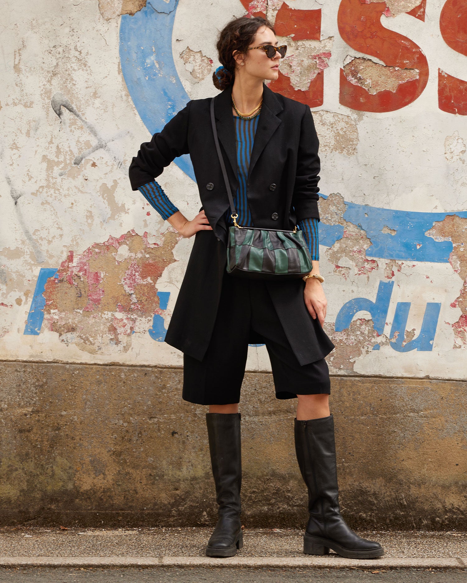 celia wearing the Black & Deep Sea Belle crossbody with a black coat and boots