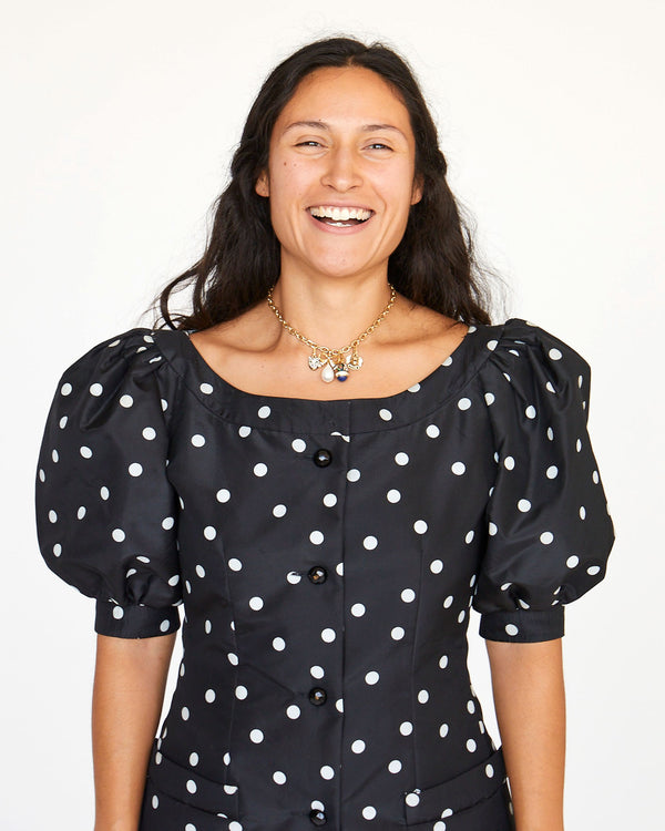 Andrea wearing the Bow & Pearl Charm on the CV chain charm necklace with other charms