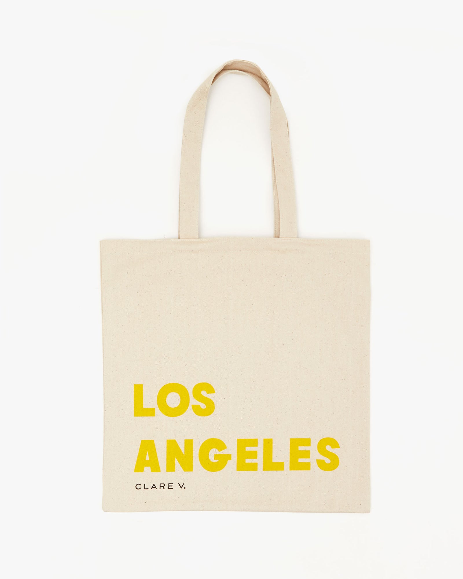 back image of the Natural Oui Canvas Store Tote. it says Los Angeles in yellow. Under that is the small Clare V. logo