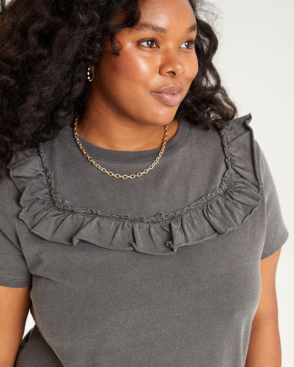 close up of the ruffles on the top portion of the Faded Black Charlotte Ruffle T-Shirt Dress worn by candice