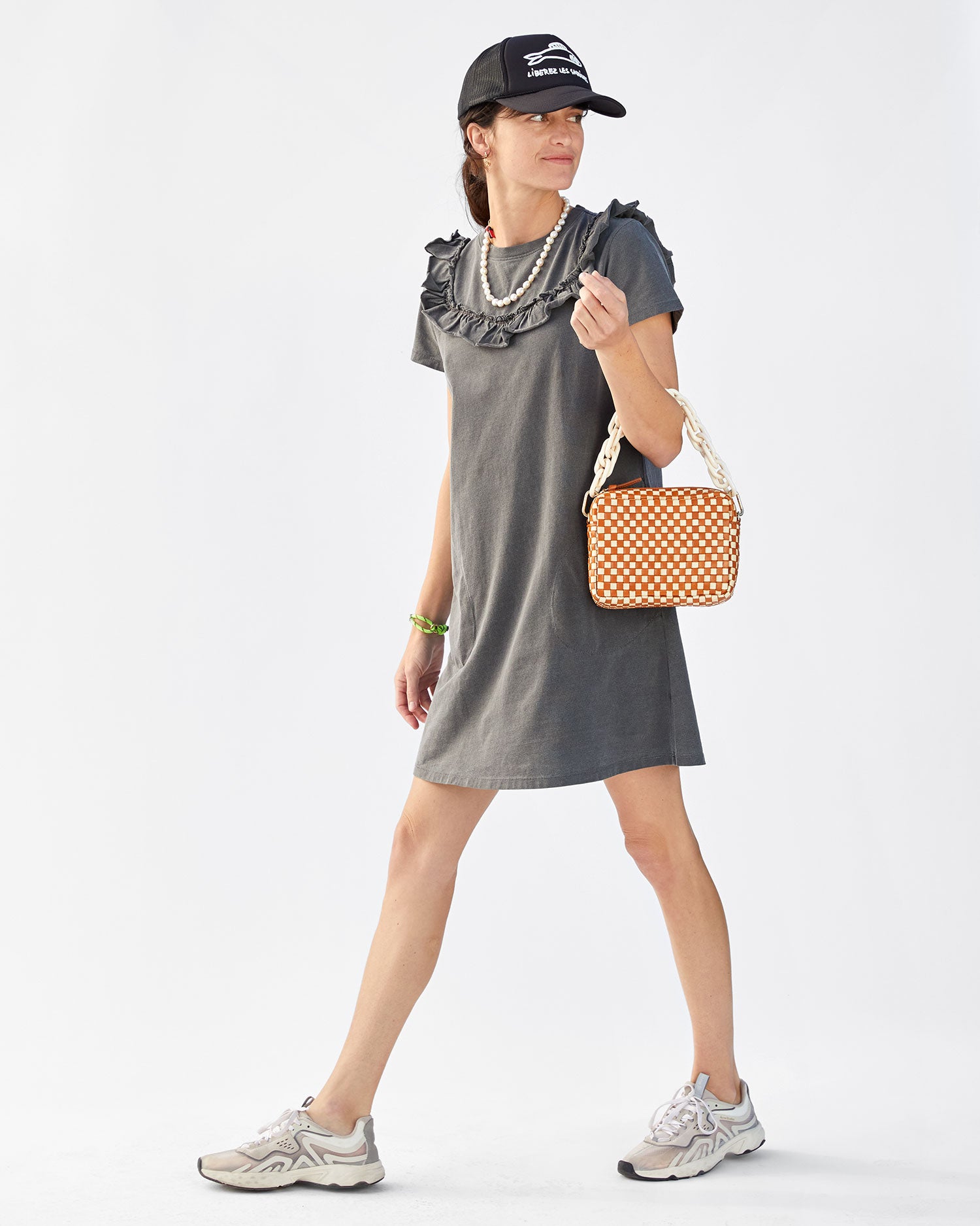 Danica wearing the Faded Black Charlotte Ruffle T-Shirt Dress with white and grey sneakers