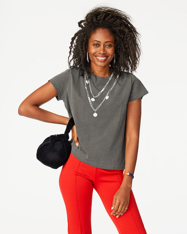 Mecca wearing a fade black tee shirt with red pants and the Black Velvet Chou Chou on her right wrist