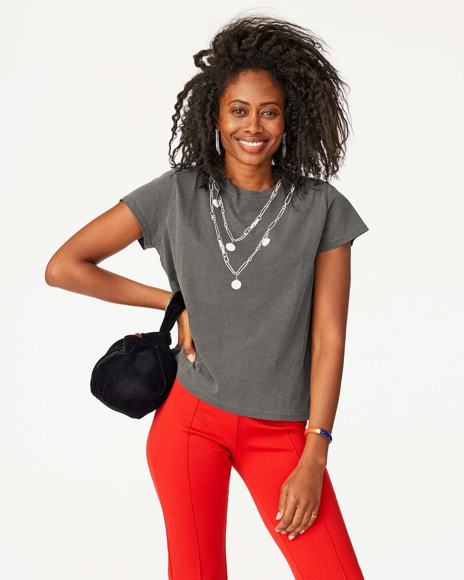 Mecca wearing a fade black tee shirt with red pants and the Black Velvet Chou Chou on her right wrist