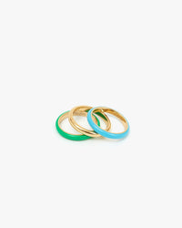 Emerald, Yellow Gold, and Turquoise Stacking Rings Laying On Top of Each Other