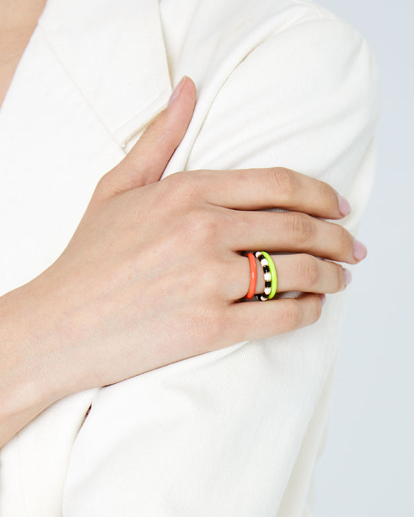 athena wearing the Coral Enamel Stacking Ring with the neon yellow stacking ring and the black and cream stripe stacking ring