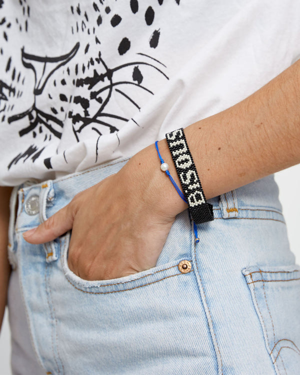 Model Wearing A Bisous Black Beaded Bracelet and Grace Lee Pearl Silk Cord Bracelet in Blue