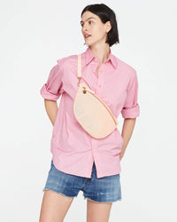 athena wearing the Ballet Perf Grande Fanny across her chest. she's wearing denim shorts and a long sleeve button up