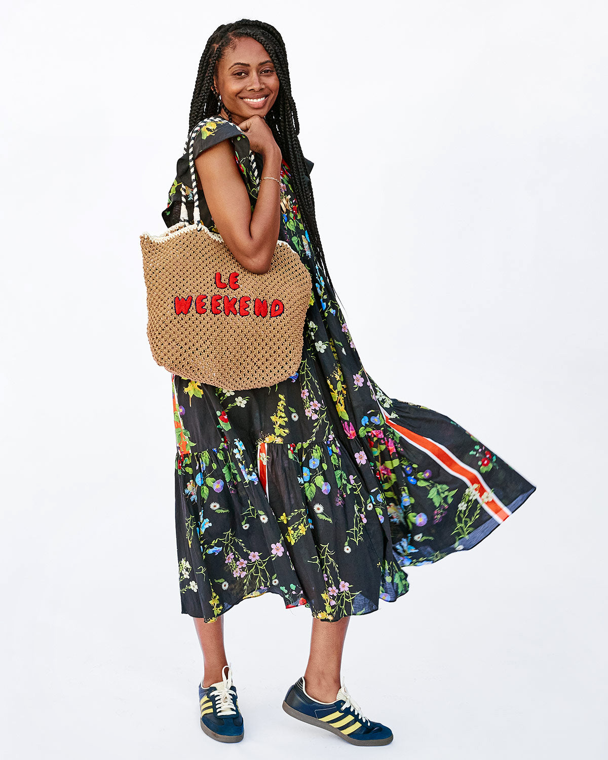 Mecca Holding the Tan Crochet Le Weekend L'Été Tote  on her Shoulder and Swinging her Dress