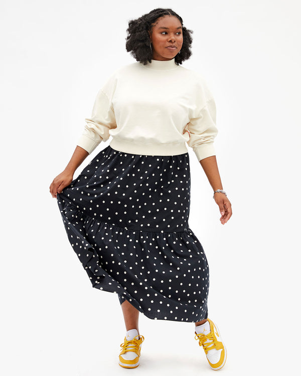 Candice wearing the Cream Le Drop Turtuleneck with the Black & White Polka Dot Manon Skirt.and Mustard and White Jordan Sneakers.