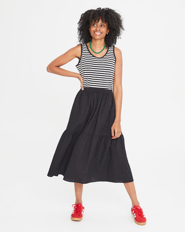 Mecca wearing the Black Eyelet Rattan Manon Skirt with a striped tank top 