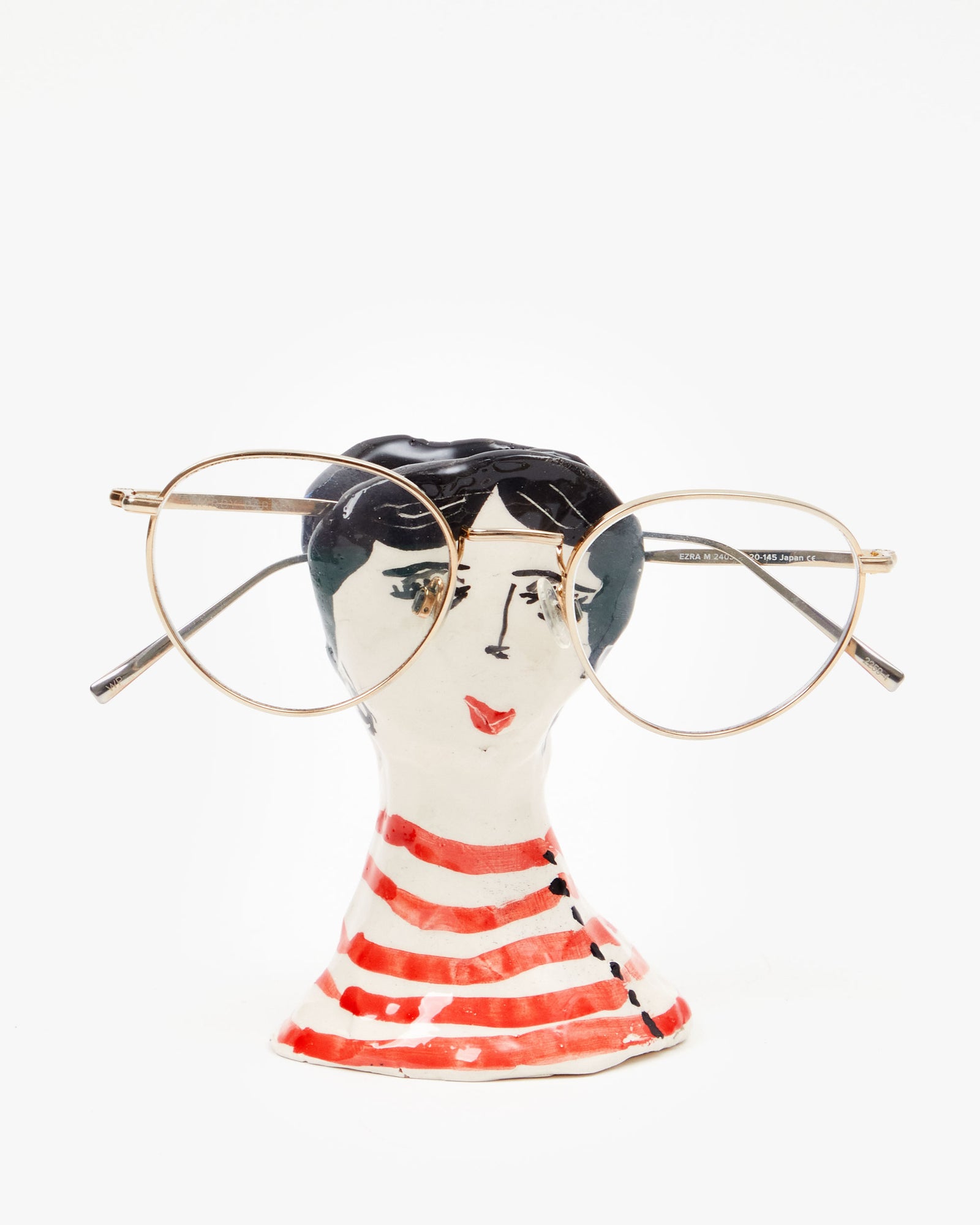 Marco Ferrini French Female Spectacles Holder with a pair of wire frame glasses on them 