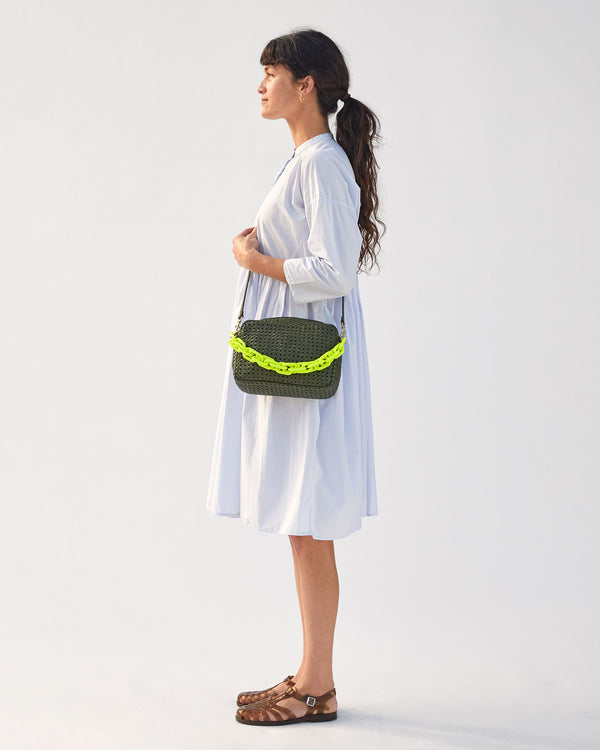 danica in a dress and sandals wearing the army rattan marisol  crossbody with the neon yellow resin shortie strap attached 