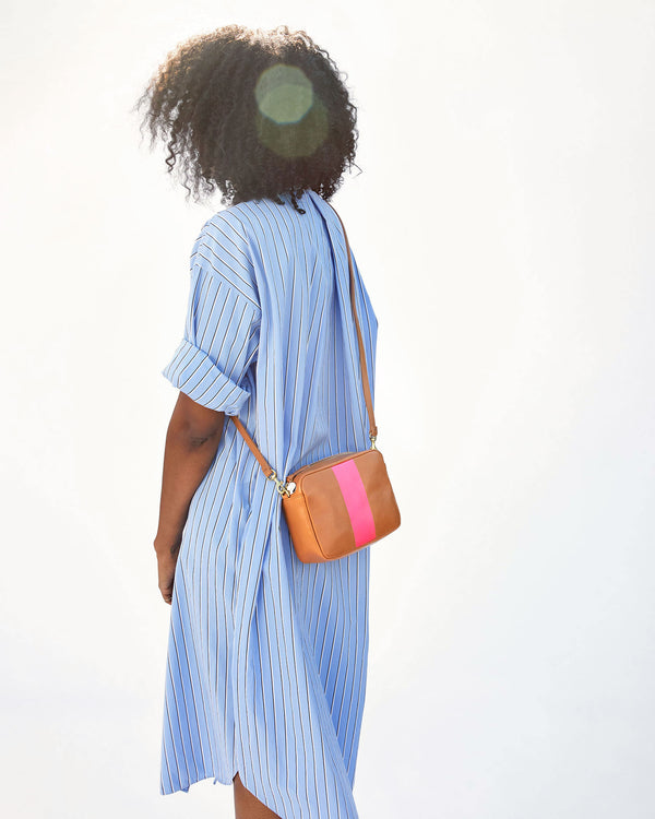 mecca wearing the Natural with Neon Pink Stripe Midi Sac crossbody. she's facing away from the camera
