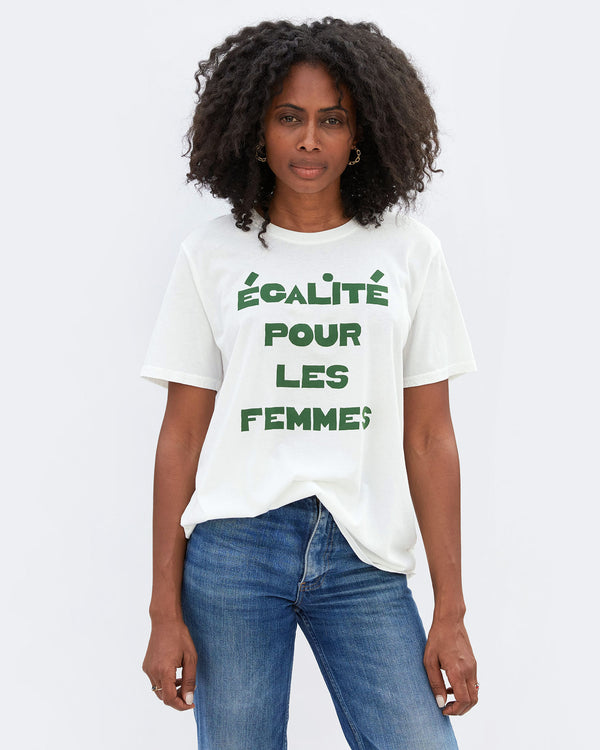 Egalite Pour Les Femmes Original Tee On Mecca Shown Slightly Tucked On The Front of Her Denim Jeans. 