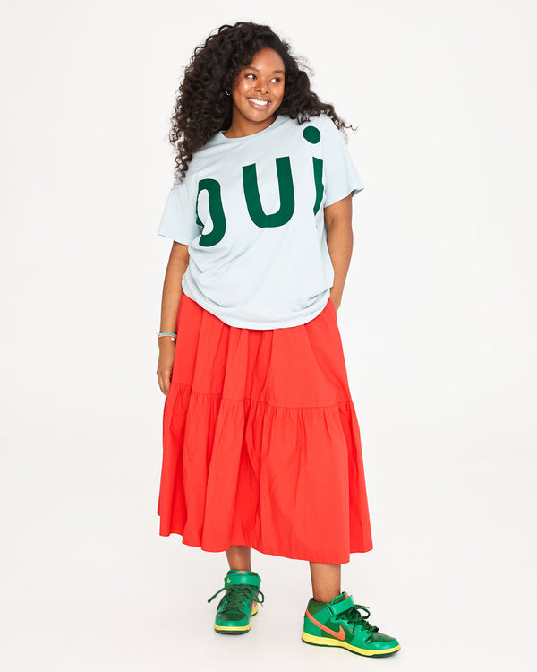 Candice wearing the Sky Blue Oui Original Tee with a bright orange skirt