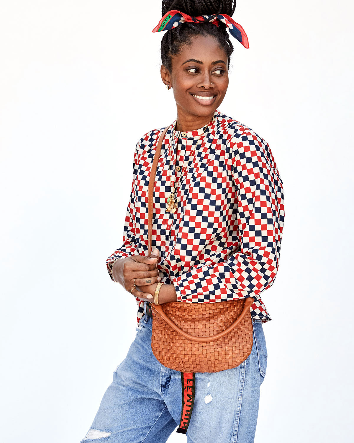 Mecca with the Red & Navy Checker Bandana in her Hair Holding the Natural Woven Checker Petit Moyen's Crossbody Strap with Both her Hands