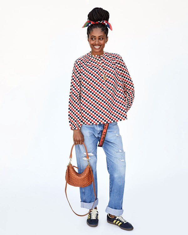 Mecca Holding the Natural Woven Checker Petit Moyen by its Shoulder Strap With Her Other Hand on her Hip