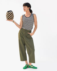danica wearing the Gazon Sun Jelly Sandals holding the black and natural checkered pot de miel in the palm of her right hand