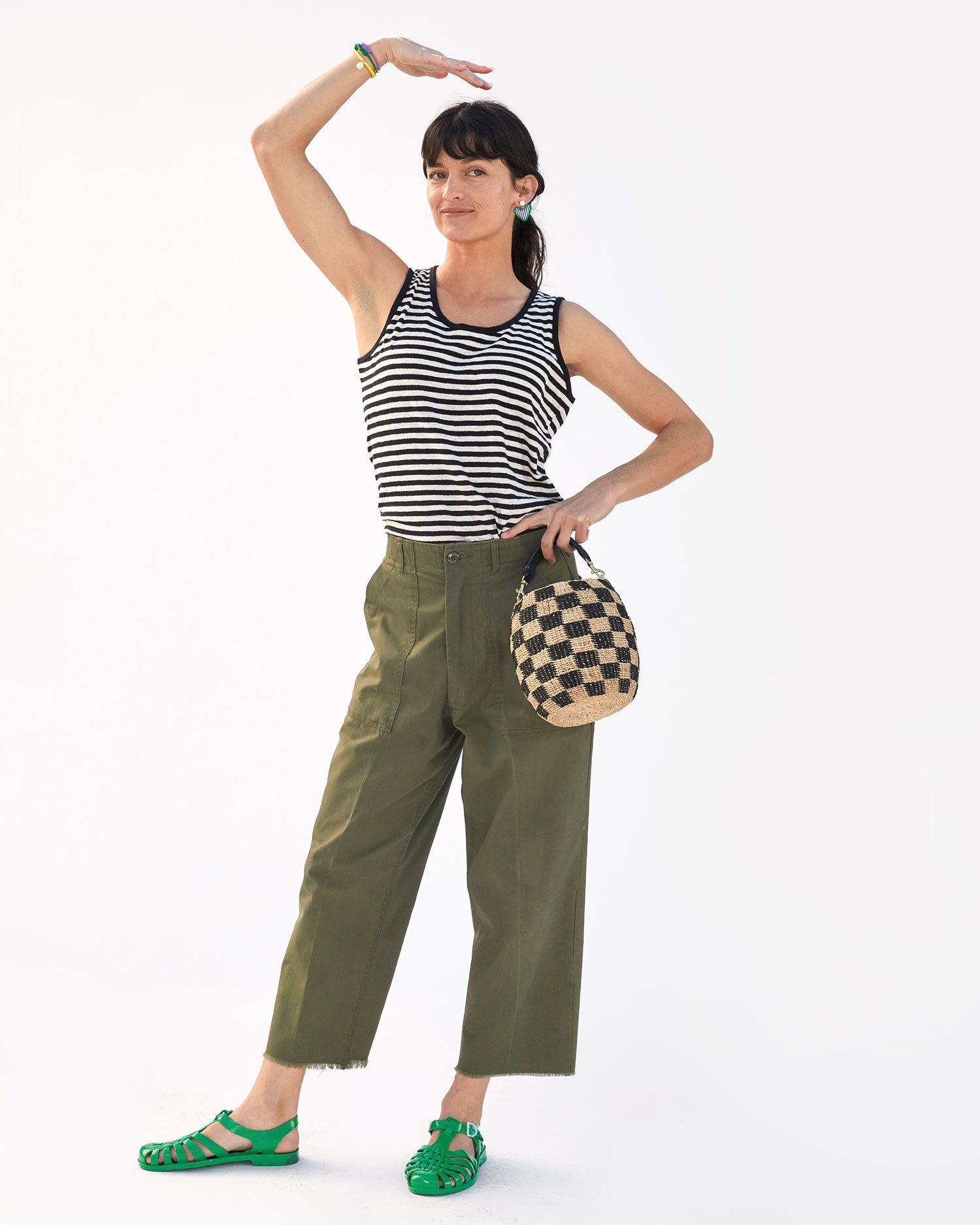 Danica wearing the Gazon Sun Jelly Sandals with army green pants  and a striped tank top