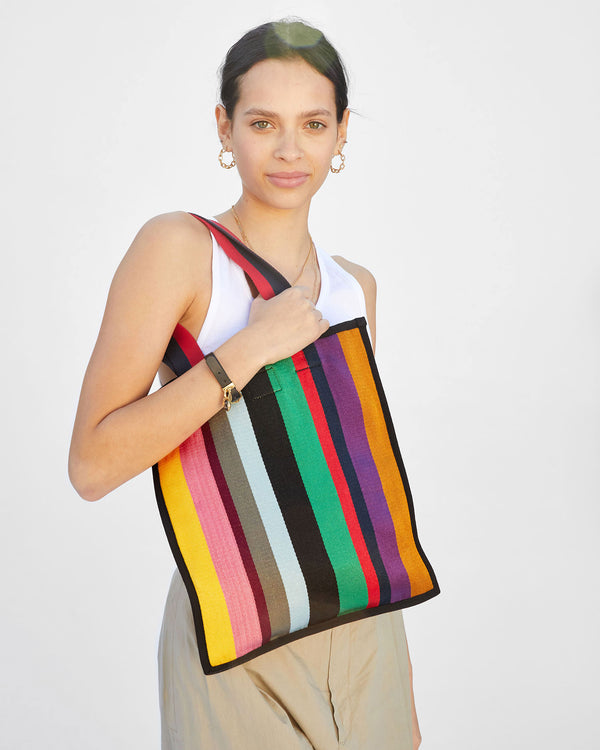 Aurelia wearing a white tank top and khakis with the Ribbon Tote