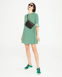 Athena wearing the Evergreen and Cream Rattan Print St. Martin Dress wearing the black fanny pack worn across her chest