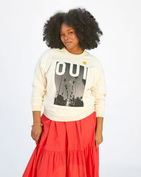 Candice wearing the Cream Oui Sweatshirt with an orange skirt