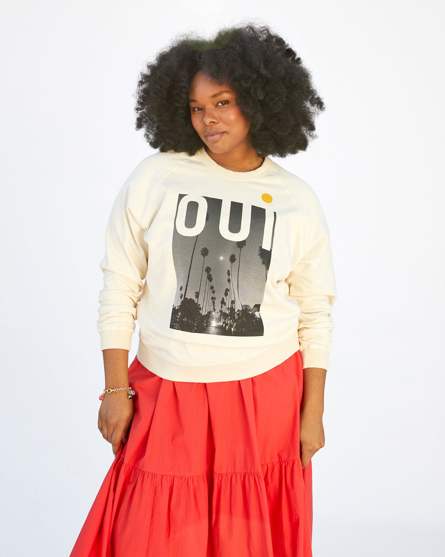 Candice wearing the Cream Oui Sweatshirt with an orange skirt